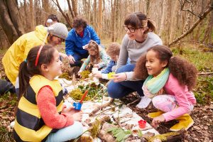teachers and kids in an outside classroom using the outdoor environment to teach
